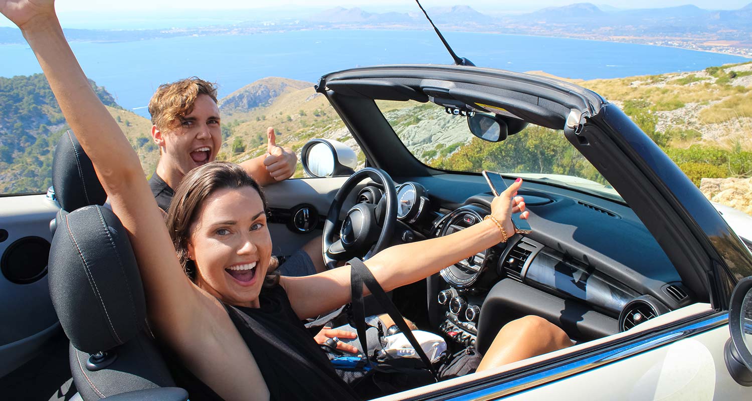 Eine Familie genießt den Urlaub mit dem Mietwagen